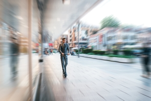 man on electric scooter on city sidewalk