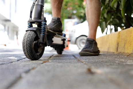 a man on an electric scooter on a sidewalk