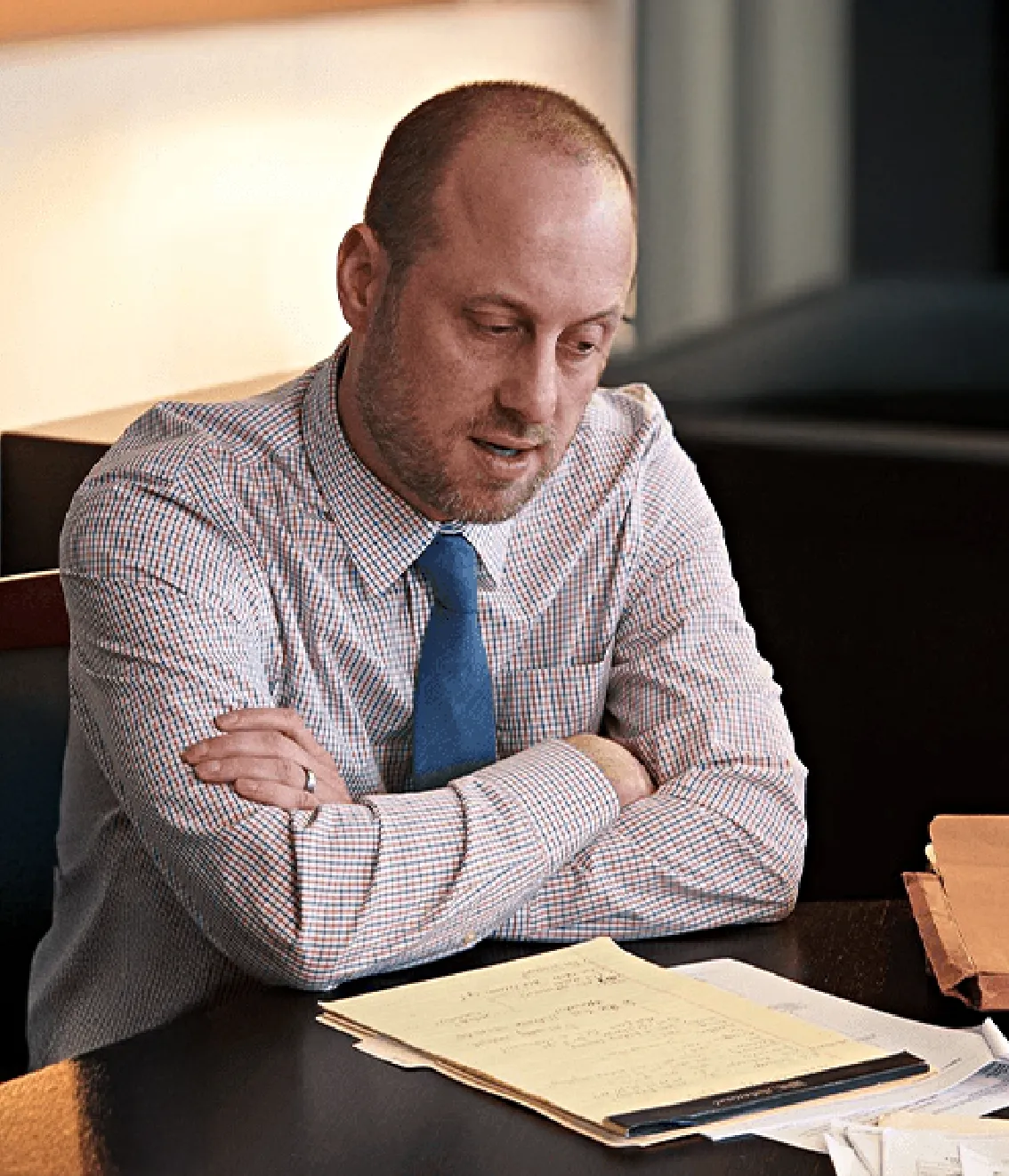 Brian Kurth, a St. Louis personal injury lawyer, talking and sitting at a desk with papers